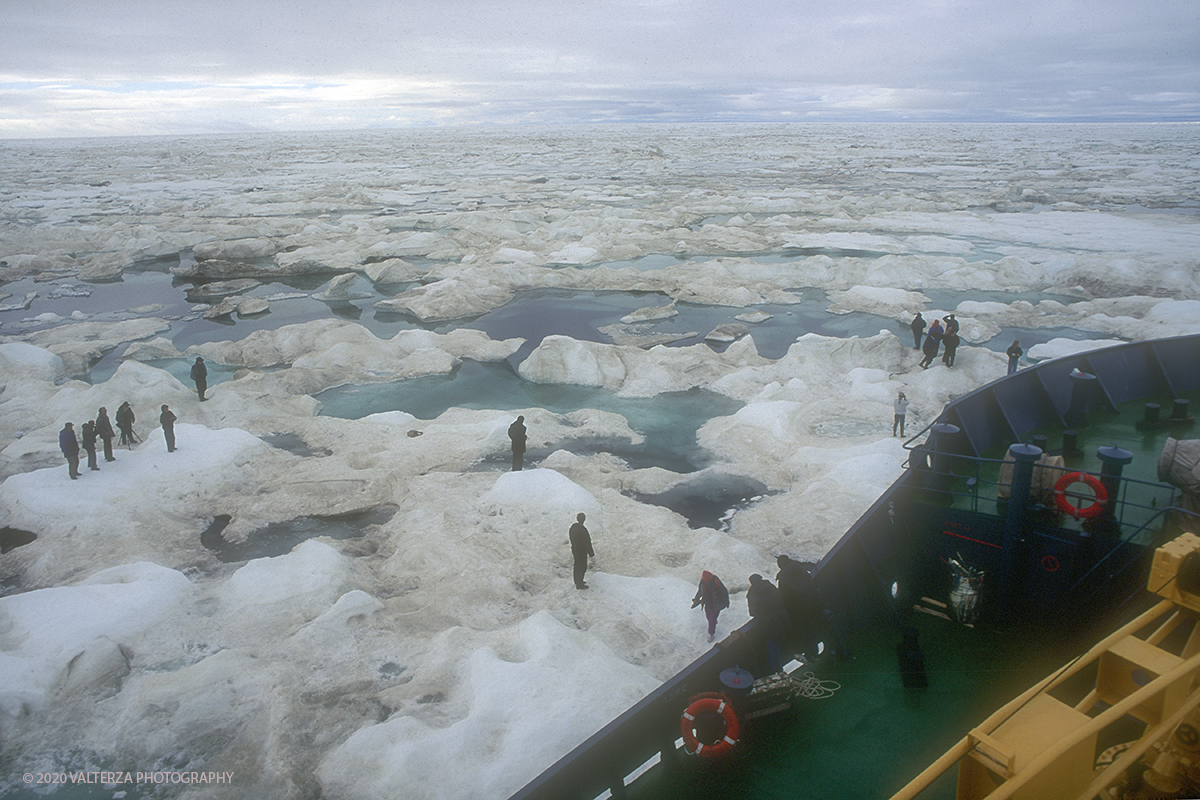 71 SIBERIA.jpg - Luglio/Agosto 1992. Siberia, terra dei Chukchi. Nell'oceano artico  125 Km a nord-est della penisola dei Chukchi (Siberia) c'Ã¨ l'isola di Wrangel, essa ospita piÃ¹ del doppio di specie vegetali (417) di qualsiasi territorio artico a paritÃ  di superficie nonchÃ¨ 30 specie diverse di uccelli oltre ad orsi polari, foche e trichechi ; per questo motivo   Ã¨ stata proclamata patrimonio dell'umanitÃ  dall'UNESCO. Nella foto la nave non puÃ² piÃ¹ procedere stretta nella morsa del ghiaccio si Ã¨ in attesa di un elicottero militare che atterrando sul ghiaccio della banchisa ci preleverÃ  per portarci a destinazione.